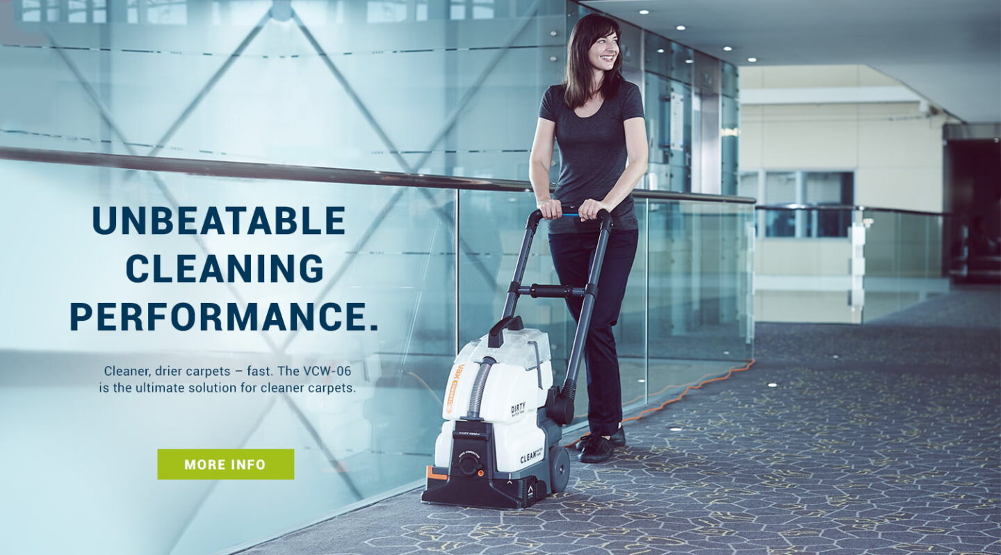 Cleaner using Vax commercial carpet washer in a corridor for campaign photography